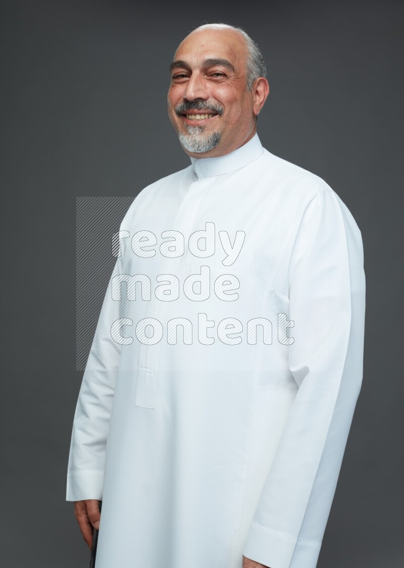 Saudi man without shomag Standing Interacting with the camera on gray background