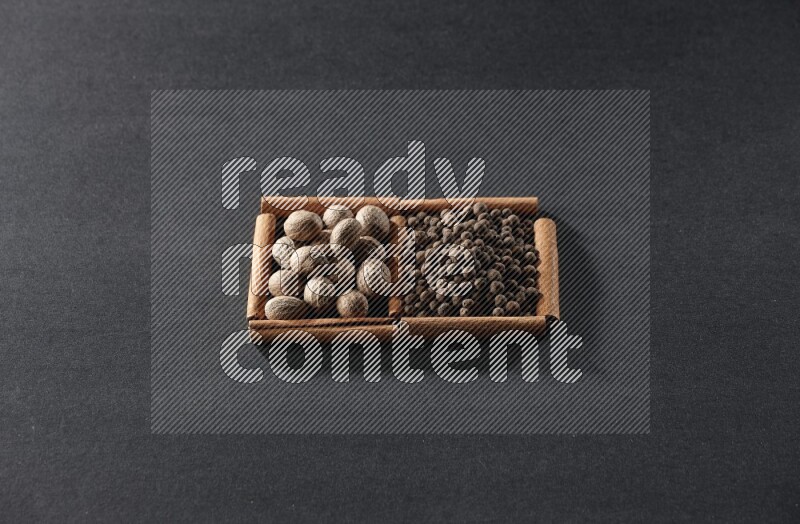 2 squares of cinnamon sticks full of nutmegs and allspice on black flooring