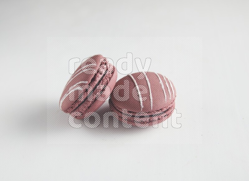 45º Shot of two Red Poppy Flower macarons on white background