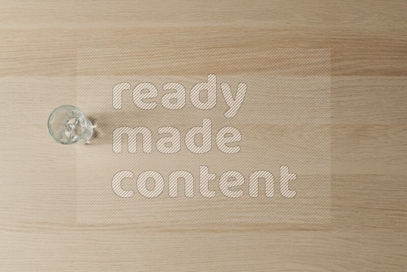 An empty glass cup on light wooden background