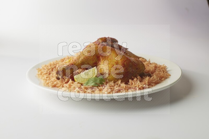 red basmati Rice with kabsa chicken pieces on a white rounded plate direct on white background