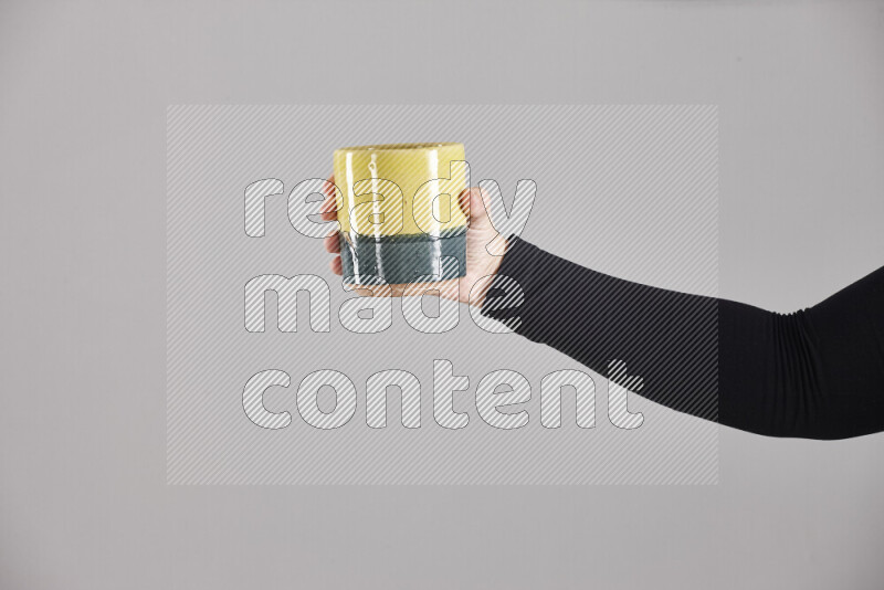 A woman in black abaya holding different pottery essentials in different positions
