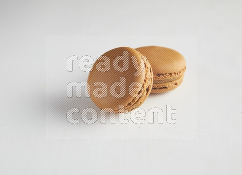 45º Shot of two Brown Maple Taffy macarons on white background