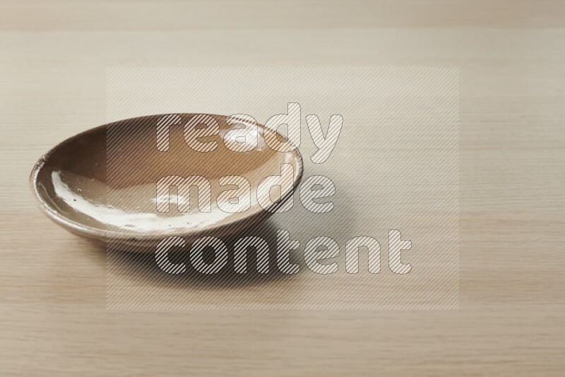 A multicolored pottery plate on light wooden background