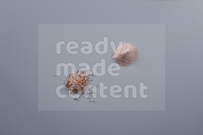 Bunches of table salt, coarse sea salt, fine himalayan salt and coarse himalayan salt on grey background