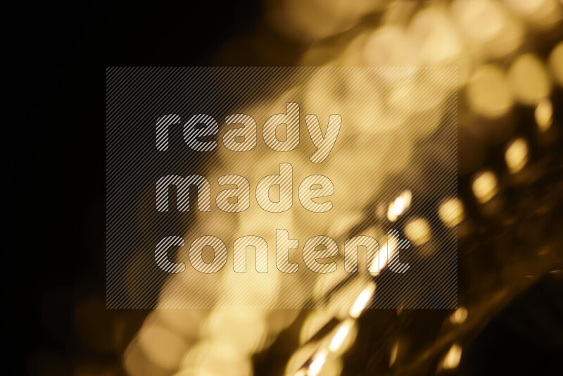 Light bulbs glowing against backdrop of golden bokeh