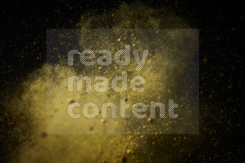 Yellow powder explosion on black background