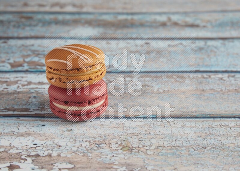 45º Shot of of two assorted Brown Irish Cream, and Red Velvet macarons on light blue background