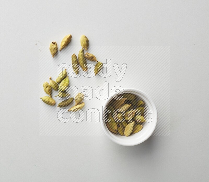 Top-view shot of Cardamon in a container on white background