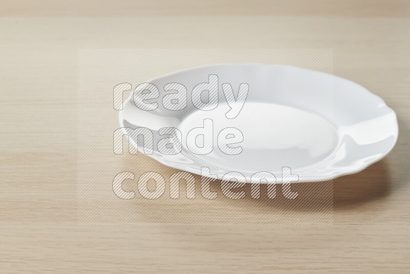 A white ceramic circular plate on light wooden background