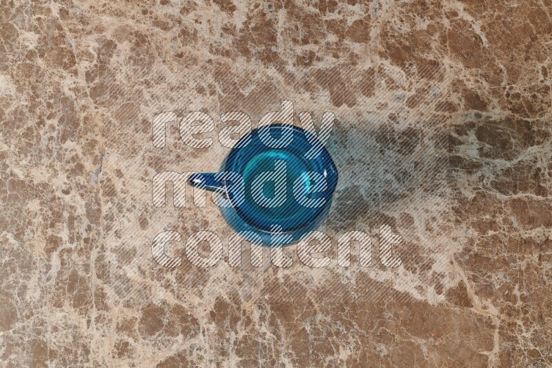 A colored glass jug on beige marble background