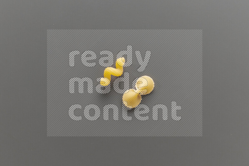 Twist pasta with other types of pasta on grey background
