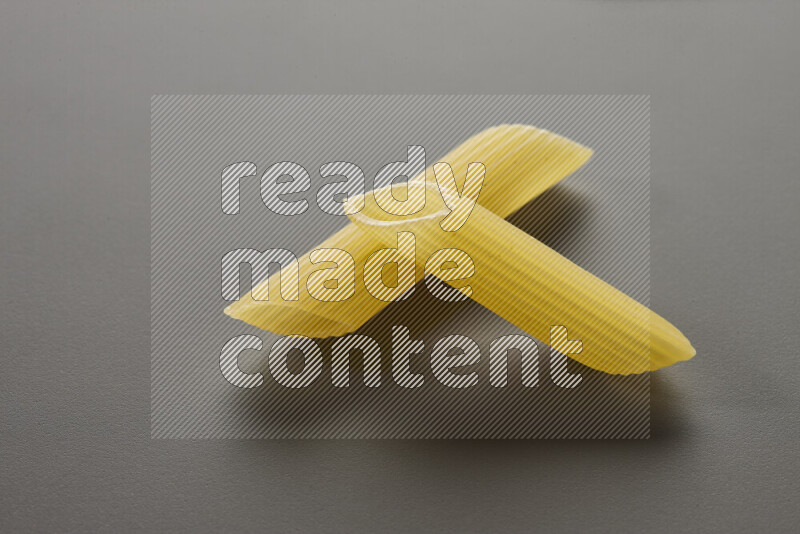 Penne pasta on grey background