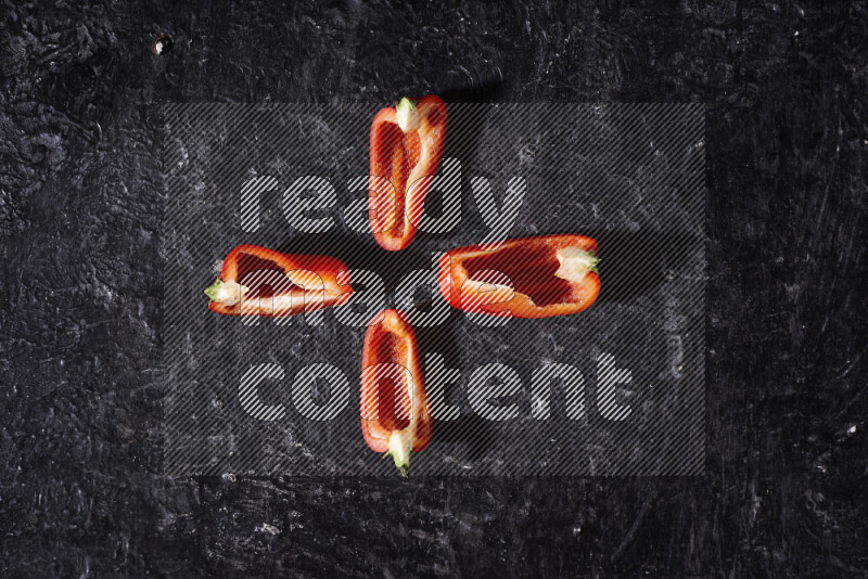 Red bell pepper slices on black background