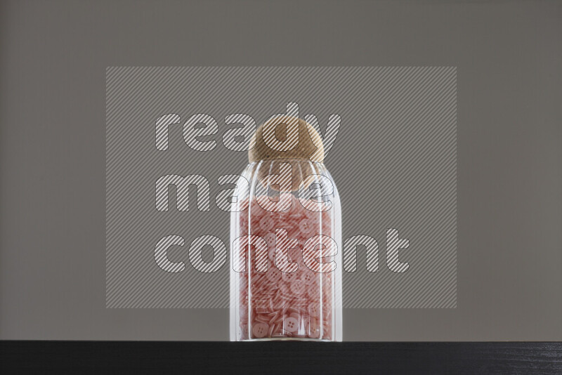 Buttons in a glass jar on black background