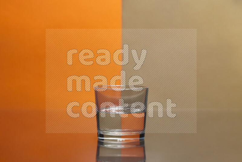 The image features a clear glassware filled with water, set against orange and beige background