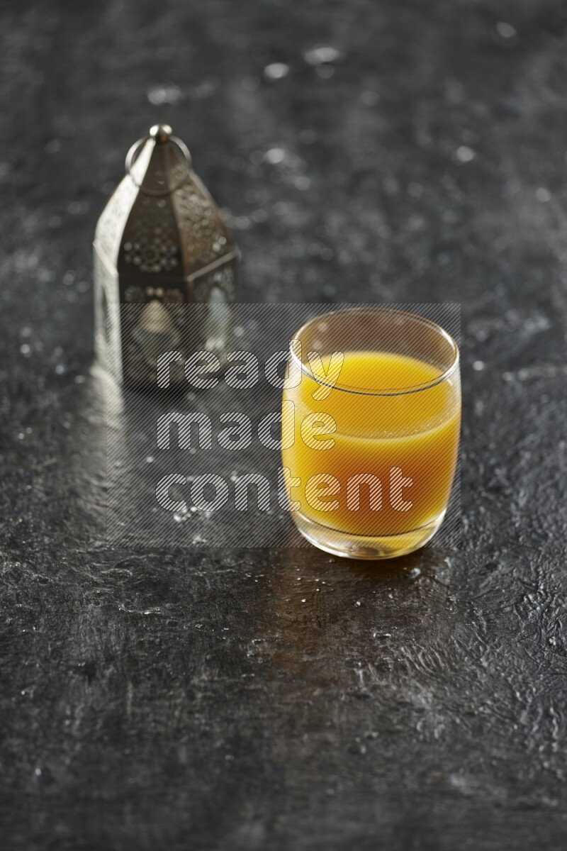 فانوس فضي مع مشروبات مختلفة وتمر ومكسرات وسبحة صلاة وقرآن على خلفية سوداء