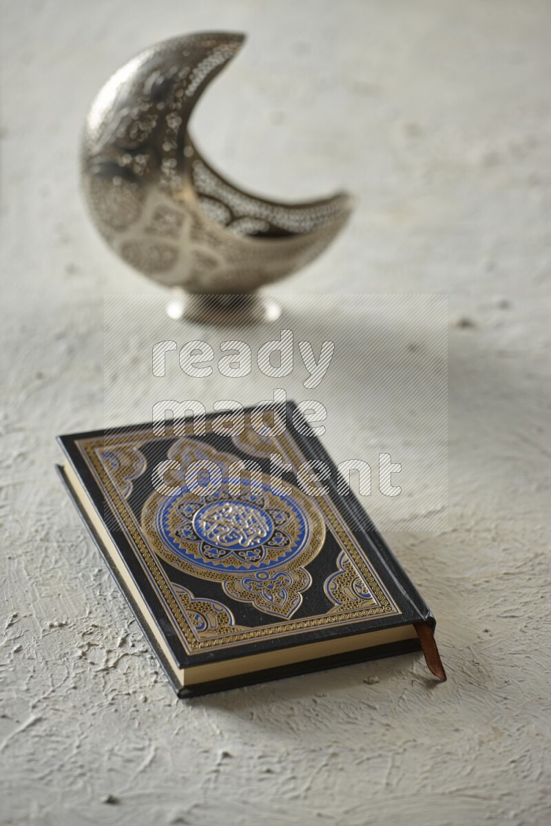 A silver lantern with different drinks, dates, nuts, prayer beads and quran on textured white background
