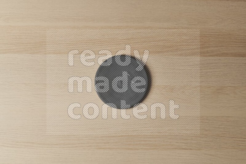 A pottery coaster on light wooden background