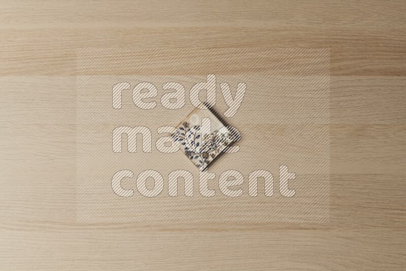 A decorative pottery coaster on light wooden background