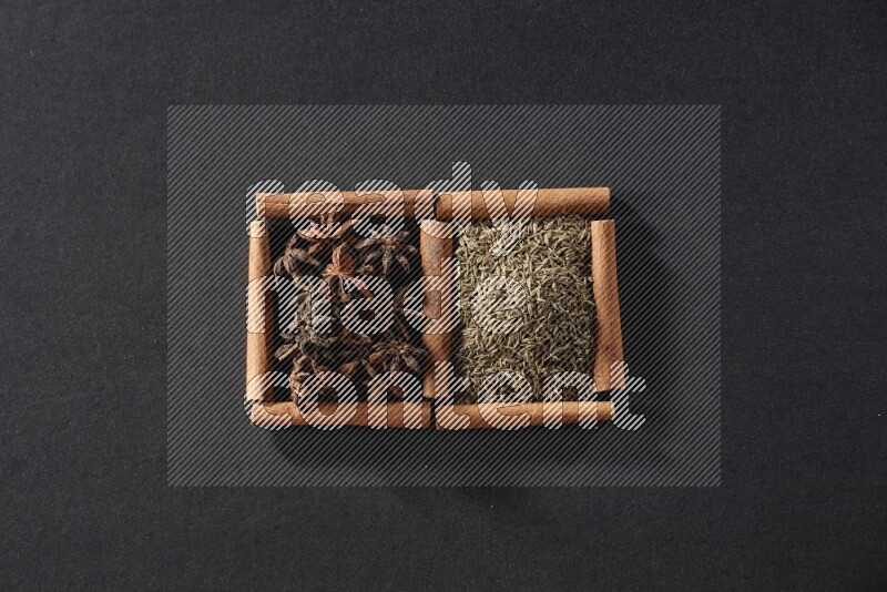 2 squares of cinnamon sticks full of cumin and star anise on black flooring