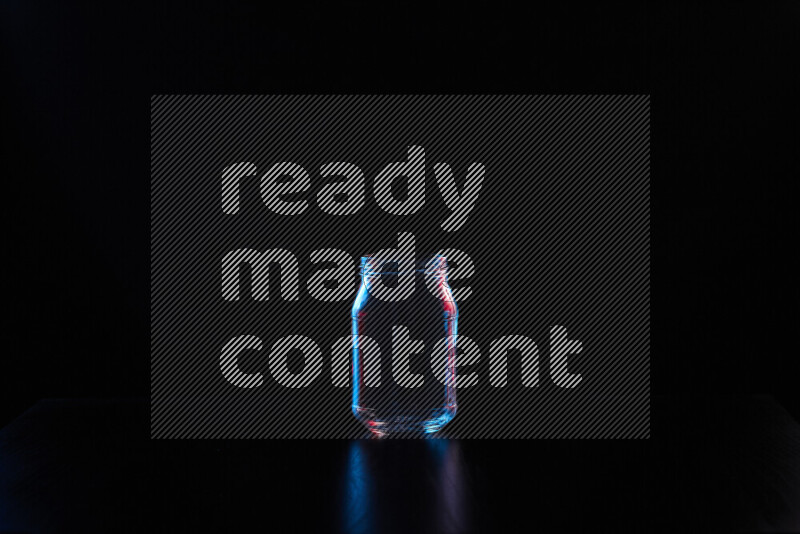 Glassware with rim light in red and blue against black background