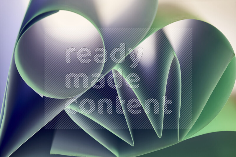 An artistic display of paper folds creating a harmonious blend of geometric shapes, highlighted by soft lighting in green tones