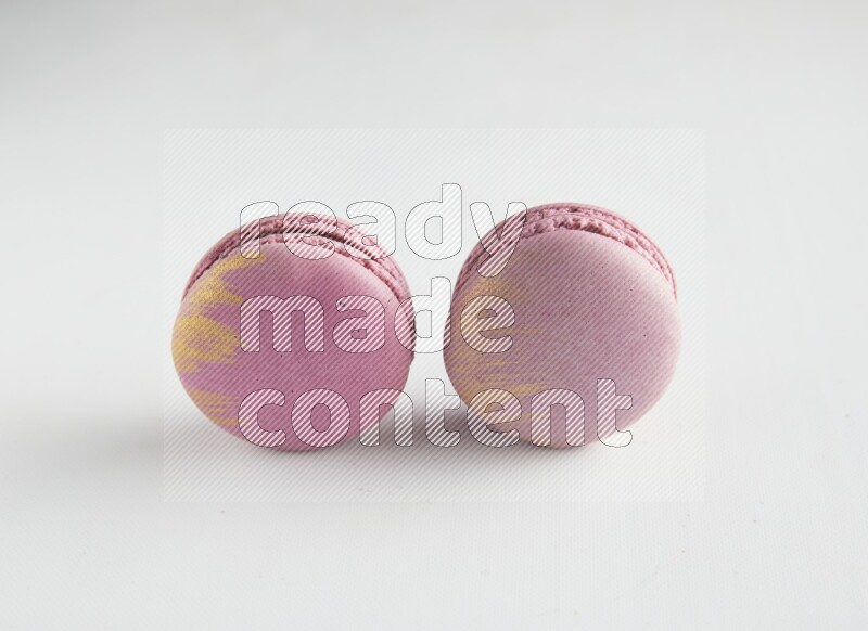 45º Shot of two Purple Strawberry macarons on white background