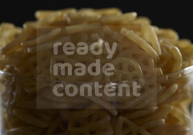 تسالي في وعاء زجاجي على خلفية سوداء