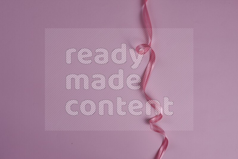 A pink collection of sewing and tailoring tools arranged on a pink background