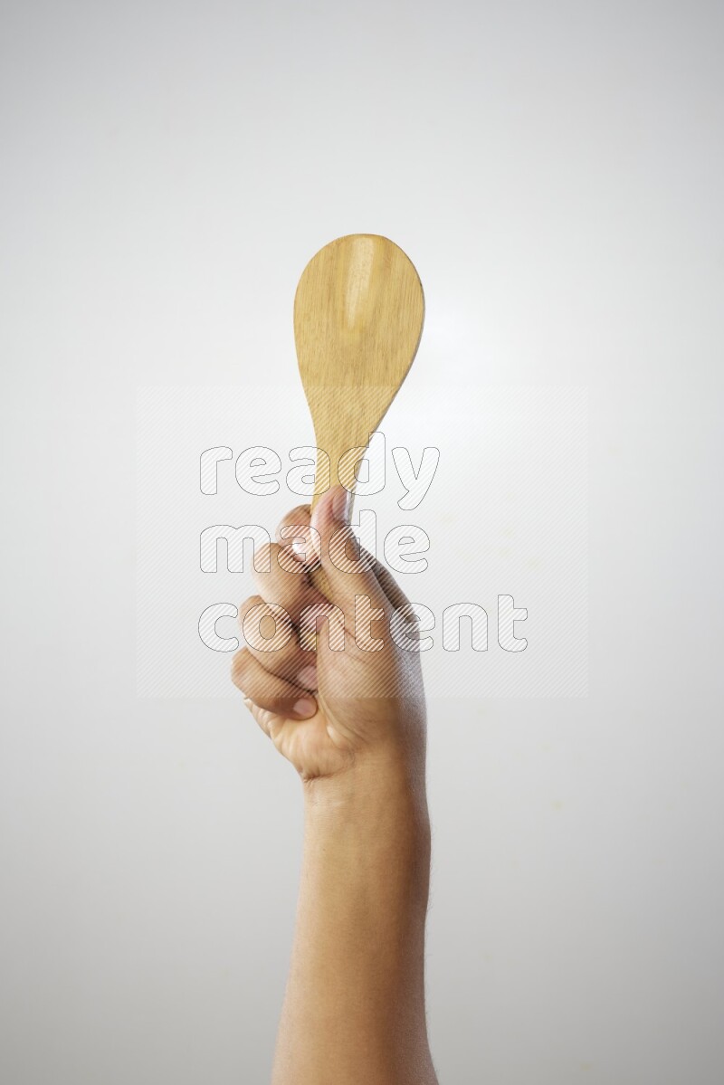 Male Hand Holding Wooden spoon on white background