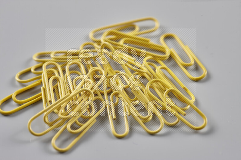 Yellow paper clips isolated on a grey background