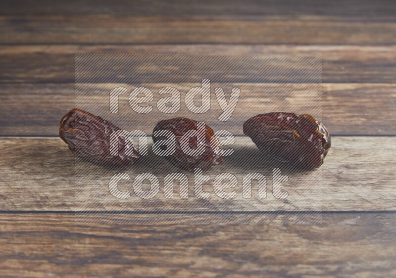 three madjoul dates on a wooden background