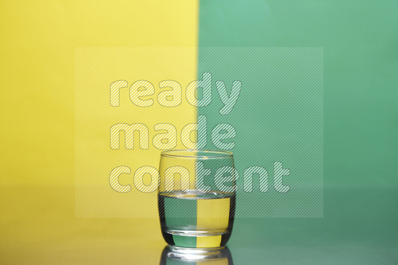 The image features a clear glassware filled with water, set against yellow and green background