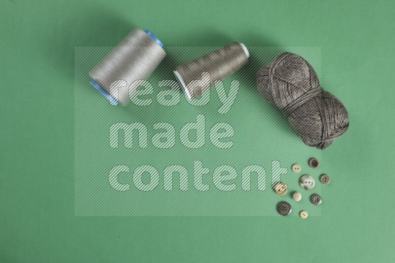 A brown collection of sewing and tailoring tools arranged on a green background