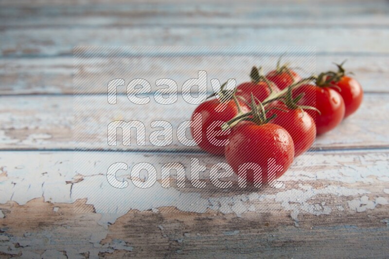 Red cherry tomato vein on a textured blue wooden background 45 degree