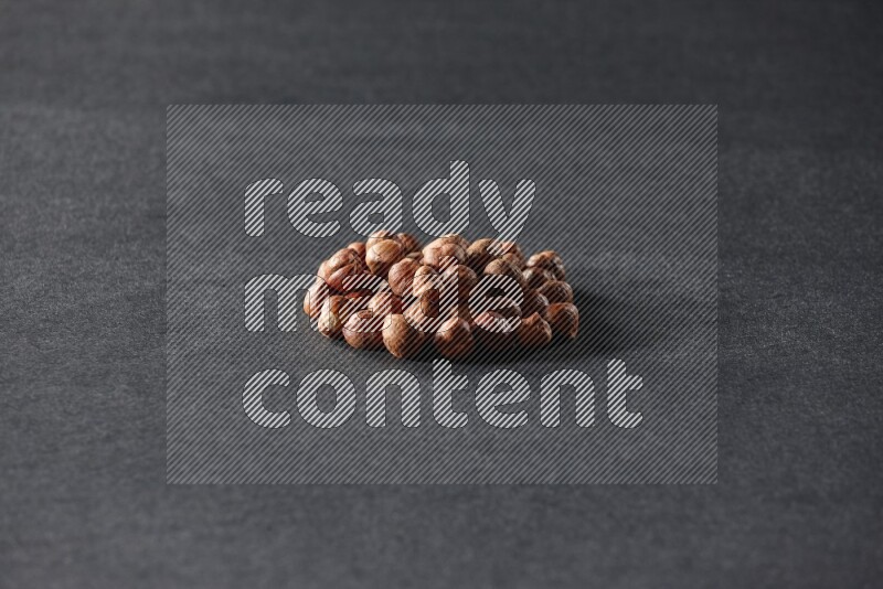 A bunch of peeled hazelnuts on a black background in different angles