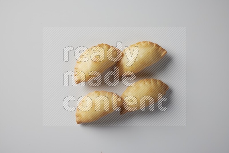 Four fried sambosa from a top angle on a white background