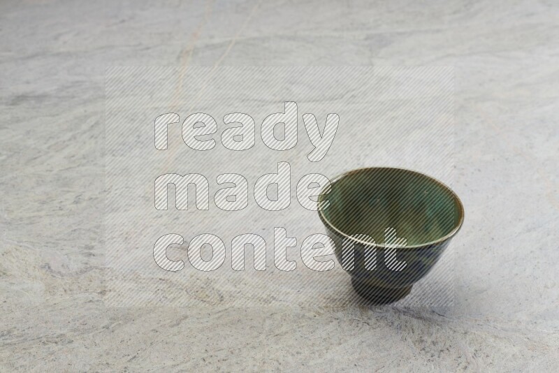 A multicolored pottery bowl on grey marble background
