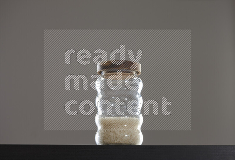 White rice in a glass jar on black background