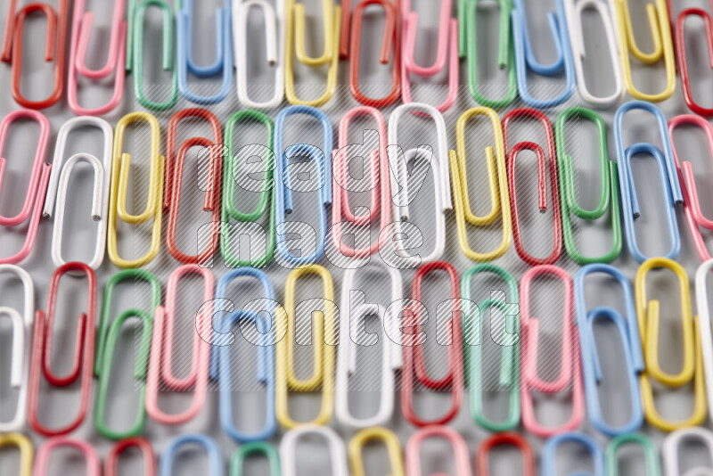 Multicolored paper clips isolated on a grey background