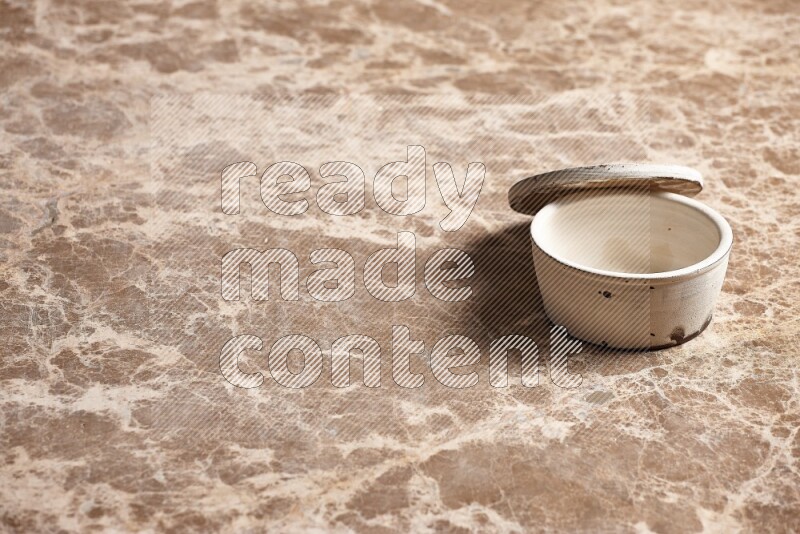 A white pottery bowl on beige marble background
