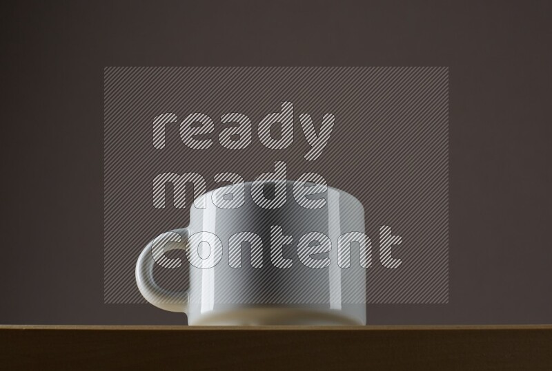 Low angle shot of a white cup on grey background