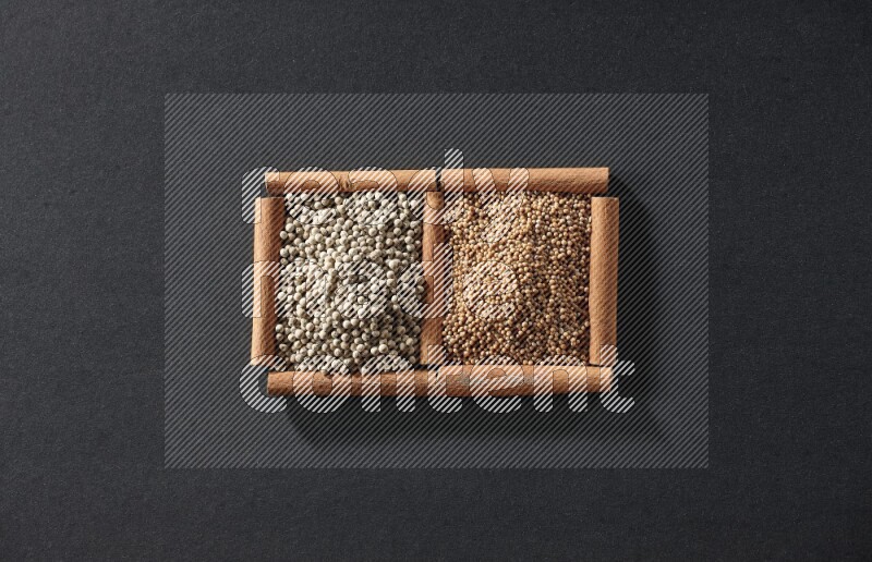 2 squares of cinnamon sticks full of mustard seeds and white peppers on black flooring