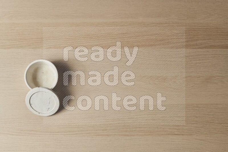 وعاء فخاري أبيض على خلفية خشبية فاتحة