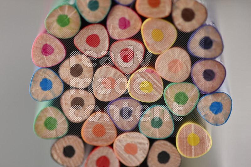An array of colored pencils on grey background