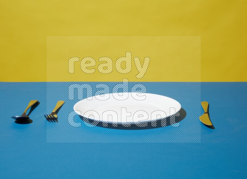 white plate and silverware on yellow and blue background