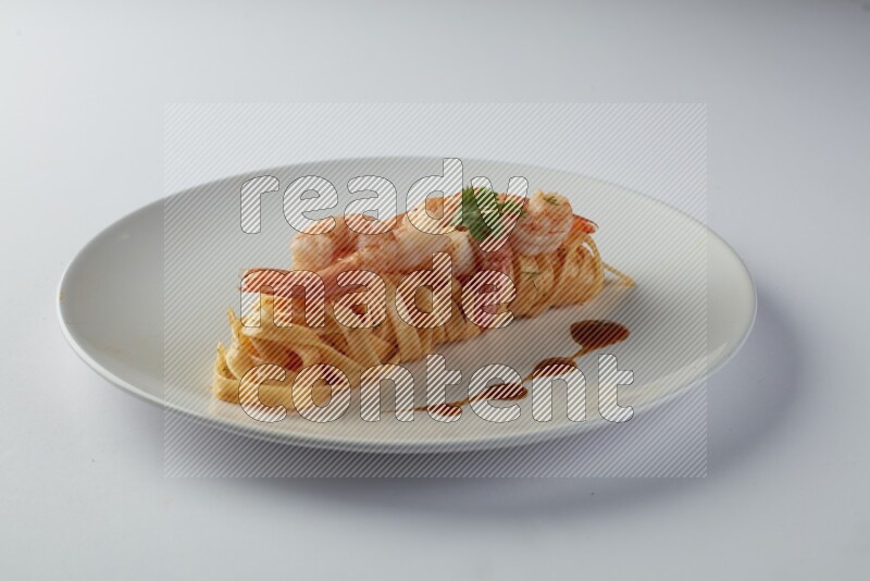 Fettuccini red sauce pasta with shrimp in a white plate on a white background
