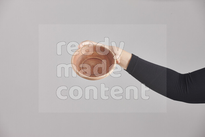 A woman in black abaya holding different wooden essentials in different positions