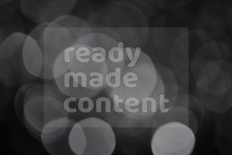 Silver shimmering fragments of glass scattered on a black background